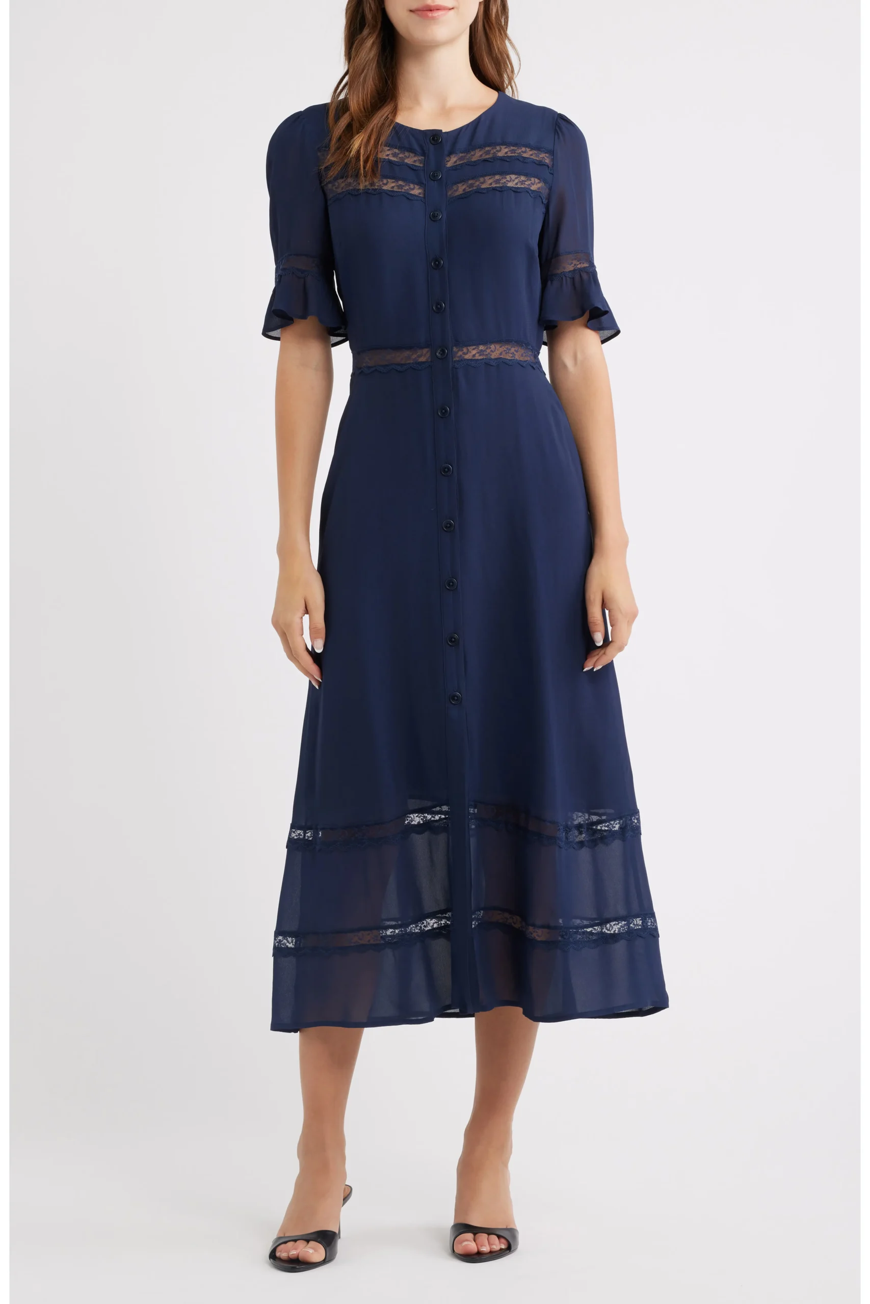 Navy blue button-down dress with lace panels, sheer lace bands at chest and hem, and short puff sleeves on a model wearing black sandals.