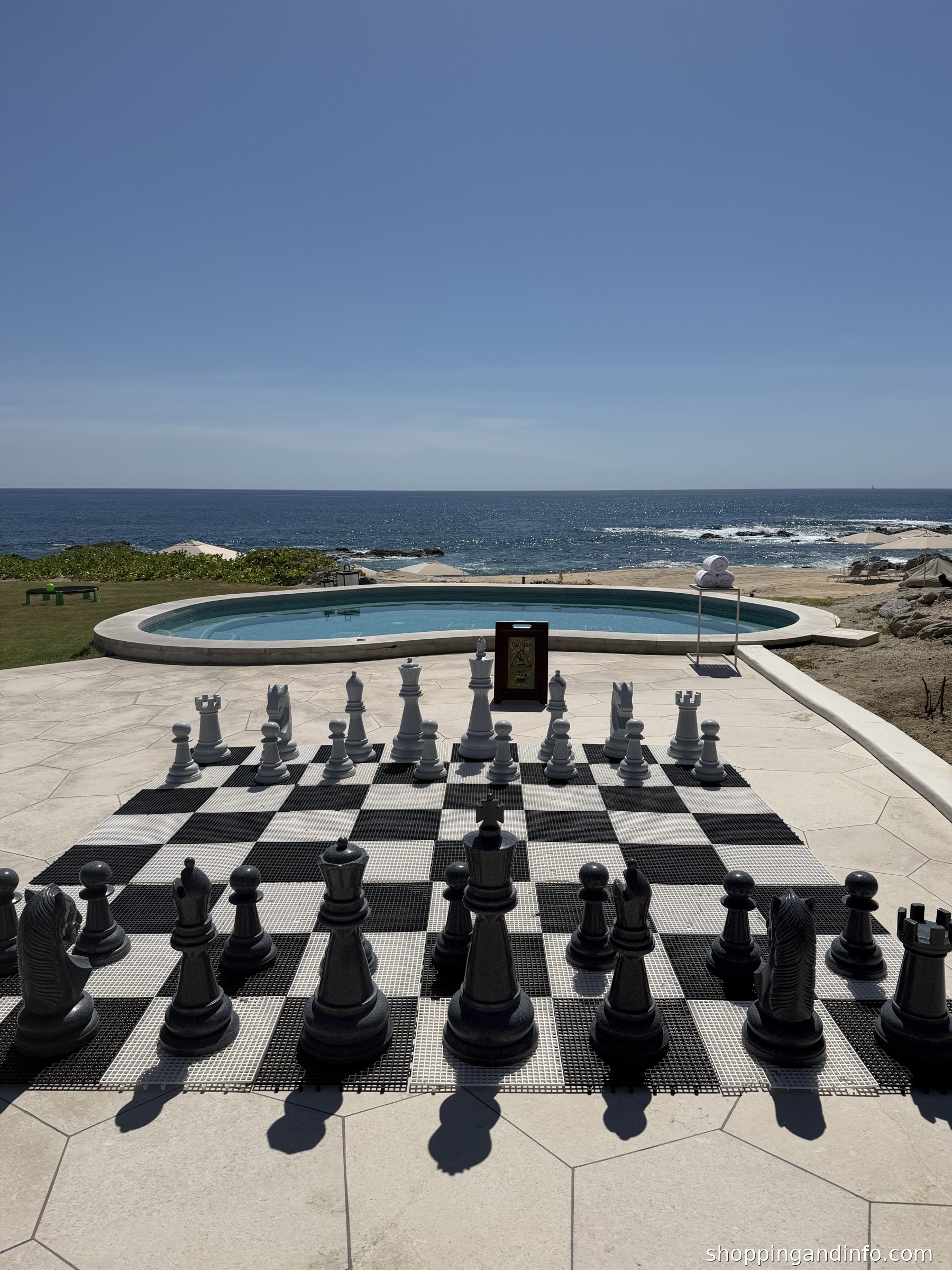 Cabo resort outfits inspiration - oceanfront chessboard and pool, photographed by Shopping and Info
