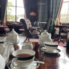 Afternoon tea in a grand hotel lounge, tartan walls and fine bone china