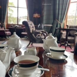 Afternoon tea in a grand hotel lounge, tartan walls and fine bone china