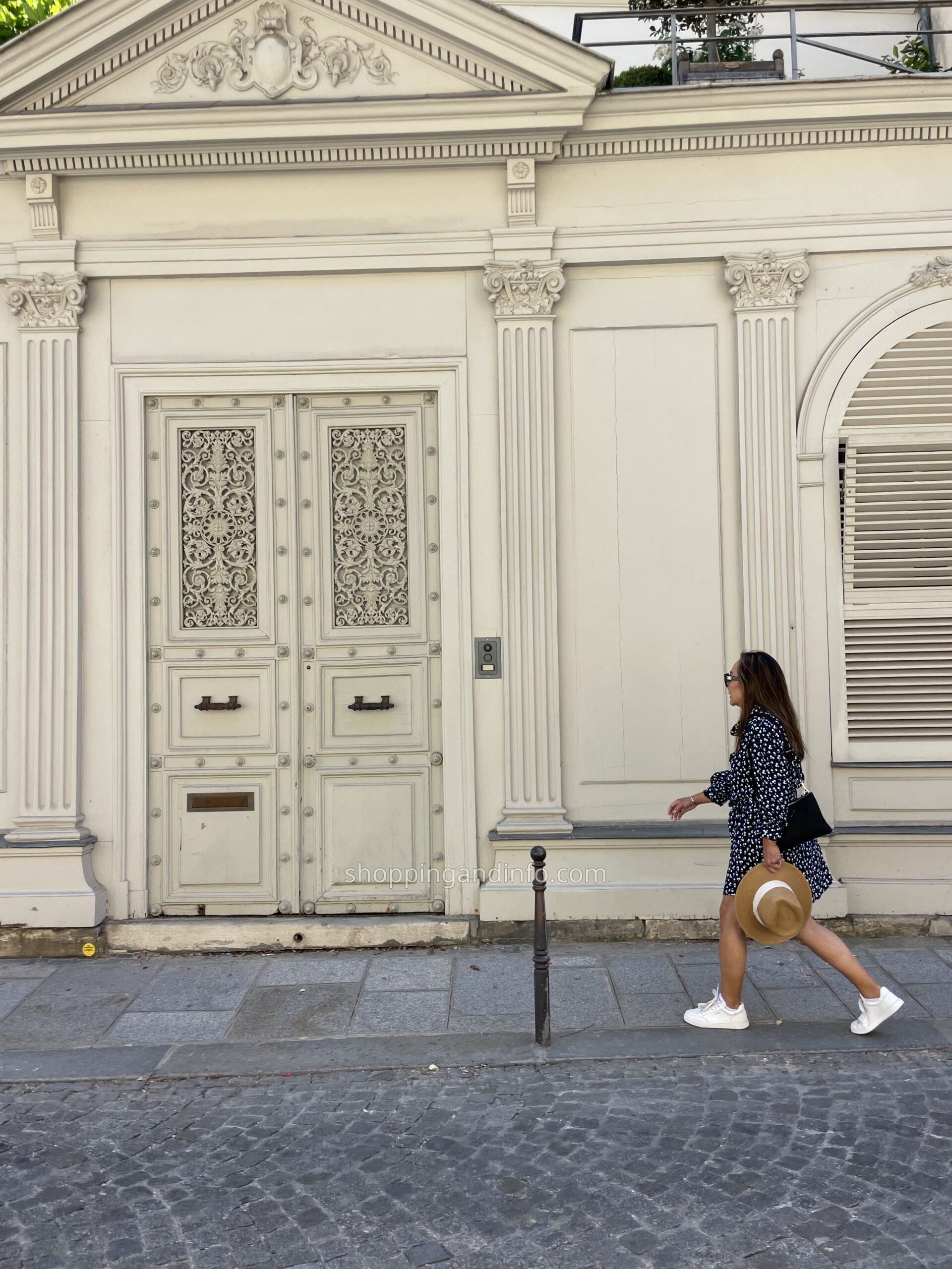 Walking in Paris wearing my navy-and-white dotted goop dress, with white sneakers and a straw hat