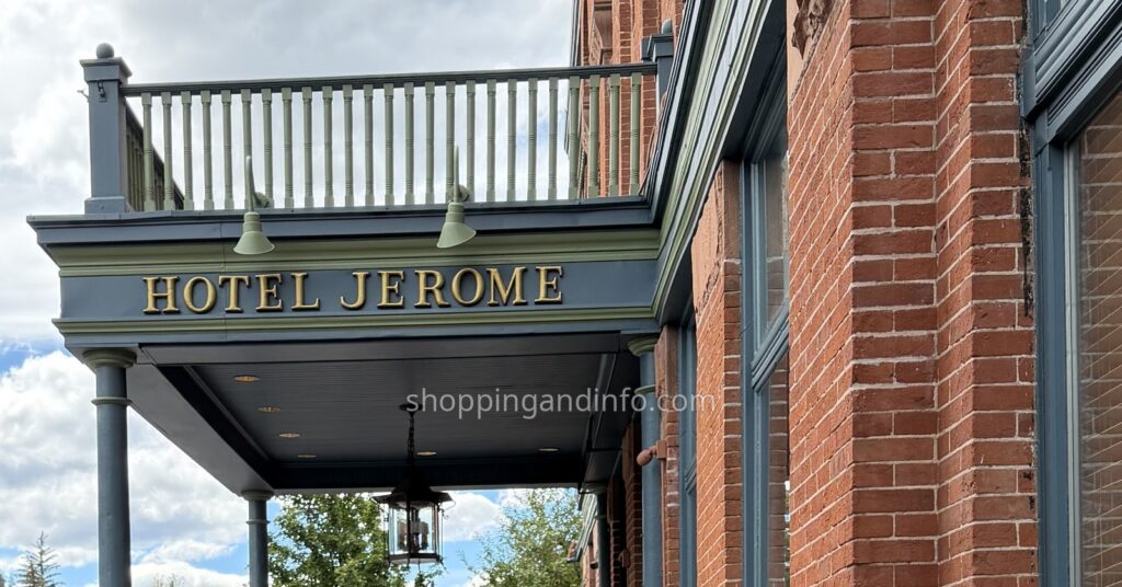 Hotel Jerome entrance sign beneath a balcony on the red-brick Aspen hotel.