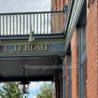 Hotel Jerome entrance sign beneath a balcony on the red-brick Aspen hotel.