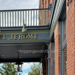 Hotel Jerome entrance sign beneath a balcony on the red-brick Aspen hotel.