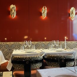 Paris restaurant interior with red lacquer wall and white tablecloths