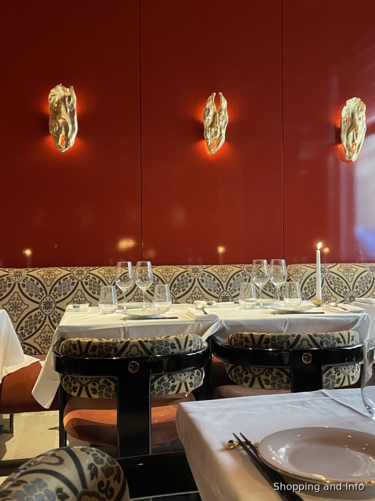 Paris restaurant interior with red lacquer wall and white tablecloths