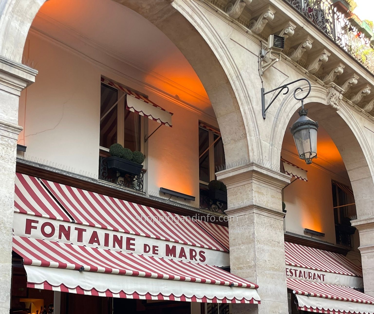 La Fontaine de Mars striped awning and stone arches in Paris
