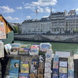 Low-profile sneakers with trousers inspiration: bookstalls beside the Seine in Paris, photographed by Shopping and Info
