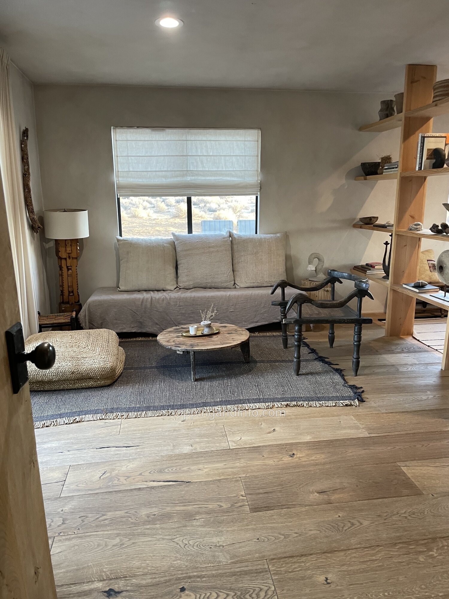The pale sofa, wood furniture and woven rug inside our desert rental