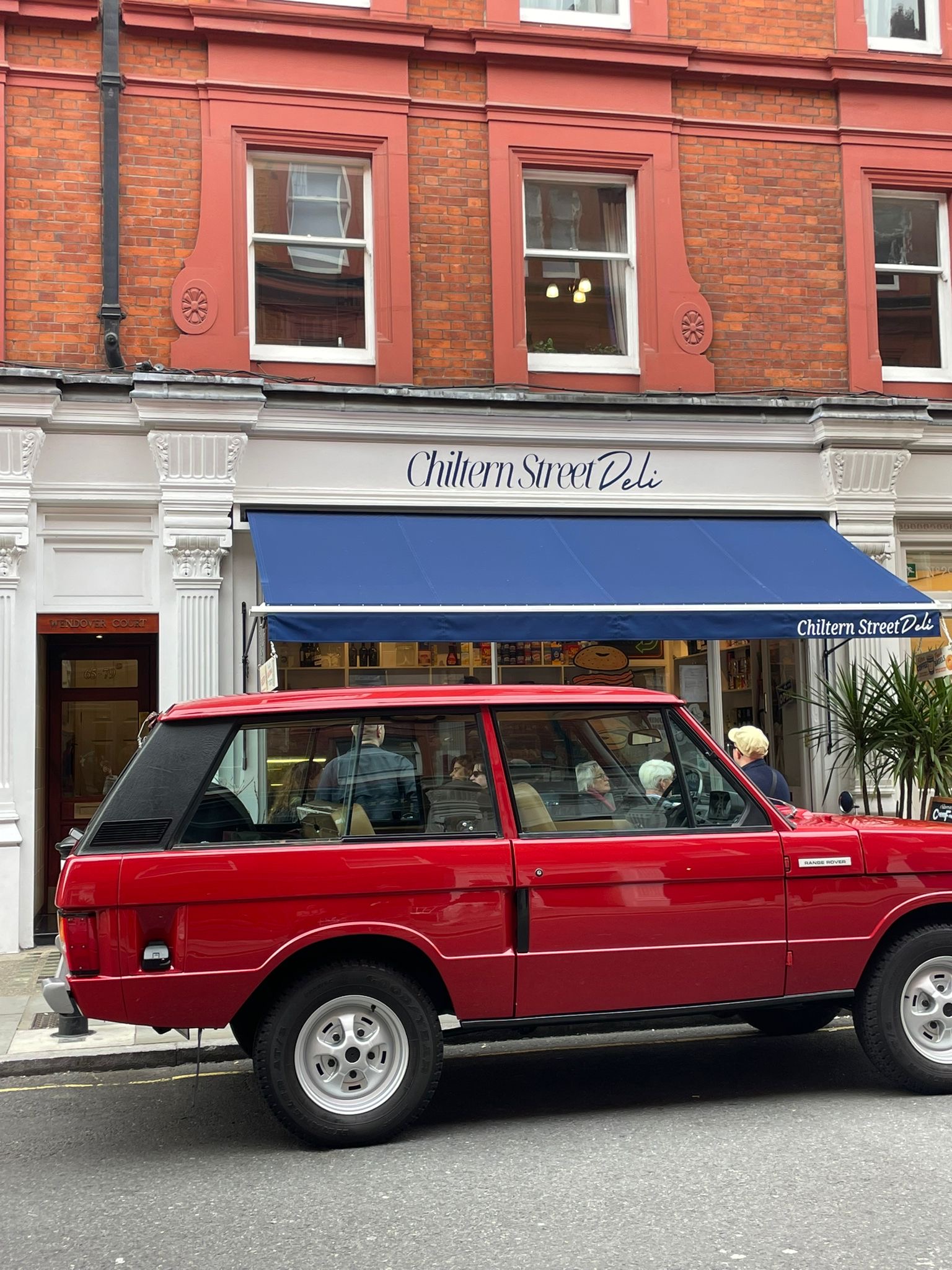 Red Range Rover outside Chiltern Street Deli in London