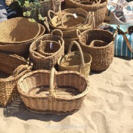 Woven market baskets on the sand at the Le Club 55 boutique in Saint-Tropez